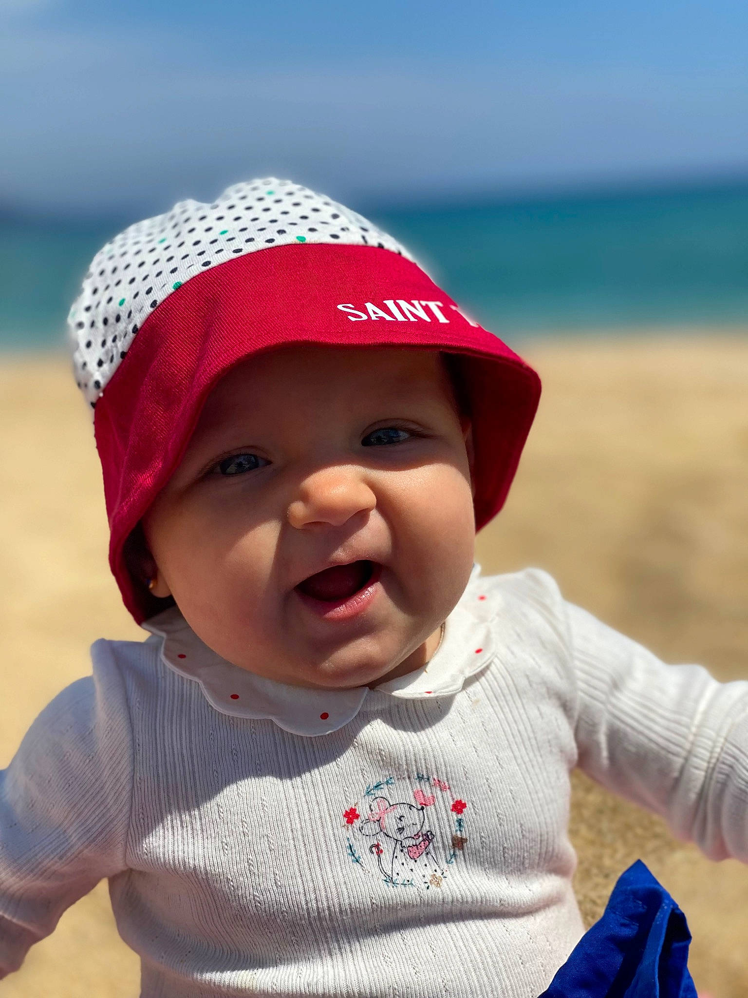 Camelia participe au concours pour gagner de l'argent avec cette photo : baby, baby_toddler_clothing, beach, cap, cheek, child, clothing, fashion_accessory, happy, hat, headgear, headwear, lip, person, personal_protective_equipment, photograph, skin, sky, sleeve, smile