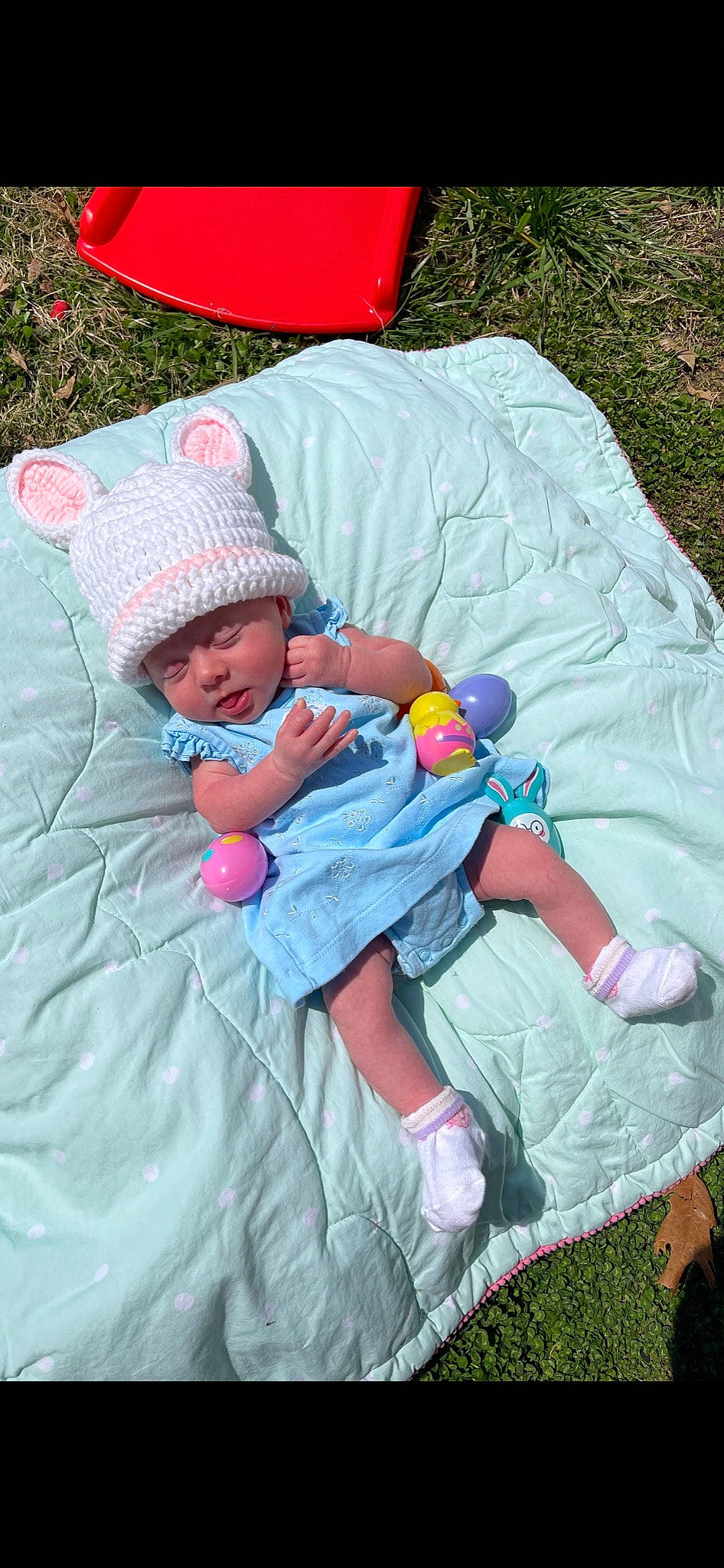Emma is registered to the contest to win money with this photo: baby, baby_products, baby_toddler_clothing, cap, child, comfort, fun, grass, headwear, lap, leaf, leisure, magenta, person, pink, plant, product, recreation, sitting, textile