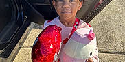Chanel joined the competition — help win amazing prizes! balloon, car_door, child, cute, fashion, girl, hair_bows, happy, heart_pattern, holding, outdoor, person, plush_toy, red_clothing, shoes, sidewalk, smile, socks, sunlight, toy