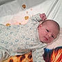 baby, infant, onesie, blanket, tiger_print, lying_down, raised_fists, cute, curious, indoor, soft_texture, child, newborn, sleepwear, patterned_clothing, face, head, skin, small_hands, portrait