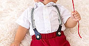 Liam joined the competition — help win amazing prizes! baby, child, infant, portrait, smiling, balloon, red_balloon, suspenders, white_shirt, red_pants, fashion, lying_down, fluffy_rug, indoor, studio, bright_lighting, blue_eyes, looking_away, playful, celebration