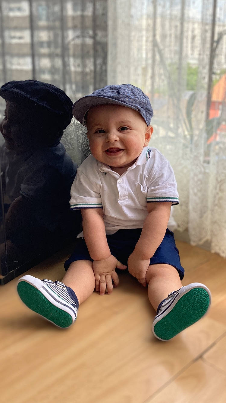 Zack a rejoint le concours — aidez-le/la à gagner de superbes lots ! baby_toddler_clothing, baseball_cap, cap, child, finger, fun, happy, hat, headgear, headwear, joy, knee, leisure, mammal, person, skin, sleeve, smile, sneakers, sock