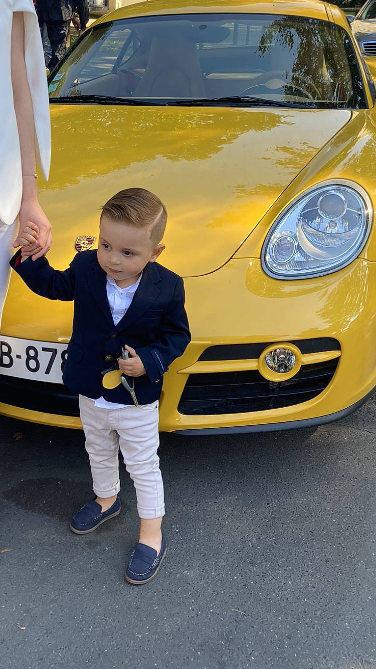 Zack a rejoint le concours — aidez-le/la à gagner de superbes lots ! alloy_wheel, auto_part, automotive_design, automotive_exterior, automotive_lighting, automotive_tire, automotive_wheel_system, bumper, car, headlamp, hood, mode_of_transport, motor_vehicle, person, personal_luxury_car, plant, rim, toddler, vehicle, vehicle_door