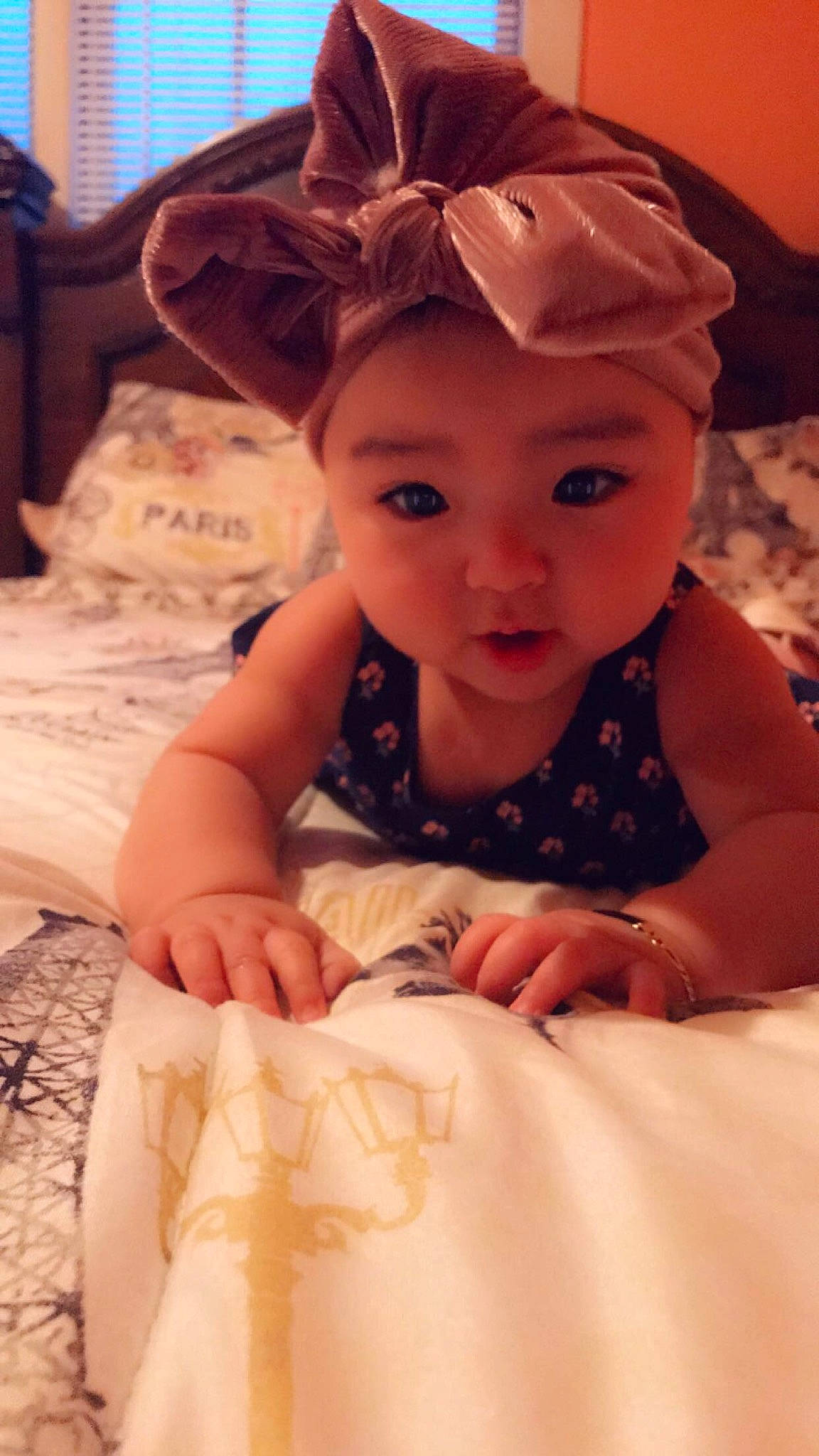 Ayana is registered to the contest to win money with this photo: baby, brown_hair, cheek, child, ear, eye, face, forehead, hair_accessory, head, headband, headgear, headwear, iris, linens, person, pink, skin, smile, textile
