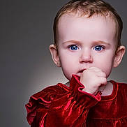 Josie joined the competition — help win amazing prizes! baby, child, portrait, face, blue_eyes, red_dress, velvet, hand, thumb, curious, innocent, close_up, studio_lighting, soft_background, cute, young, expression, person, sitting, fashion
