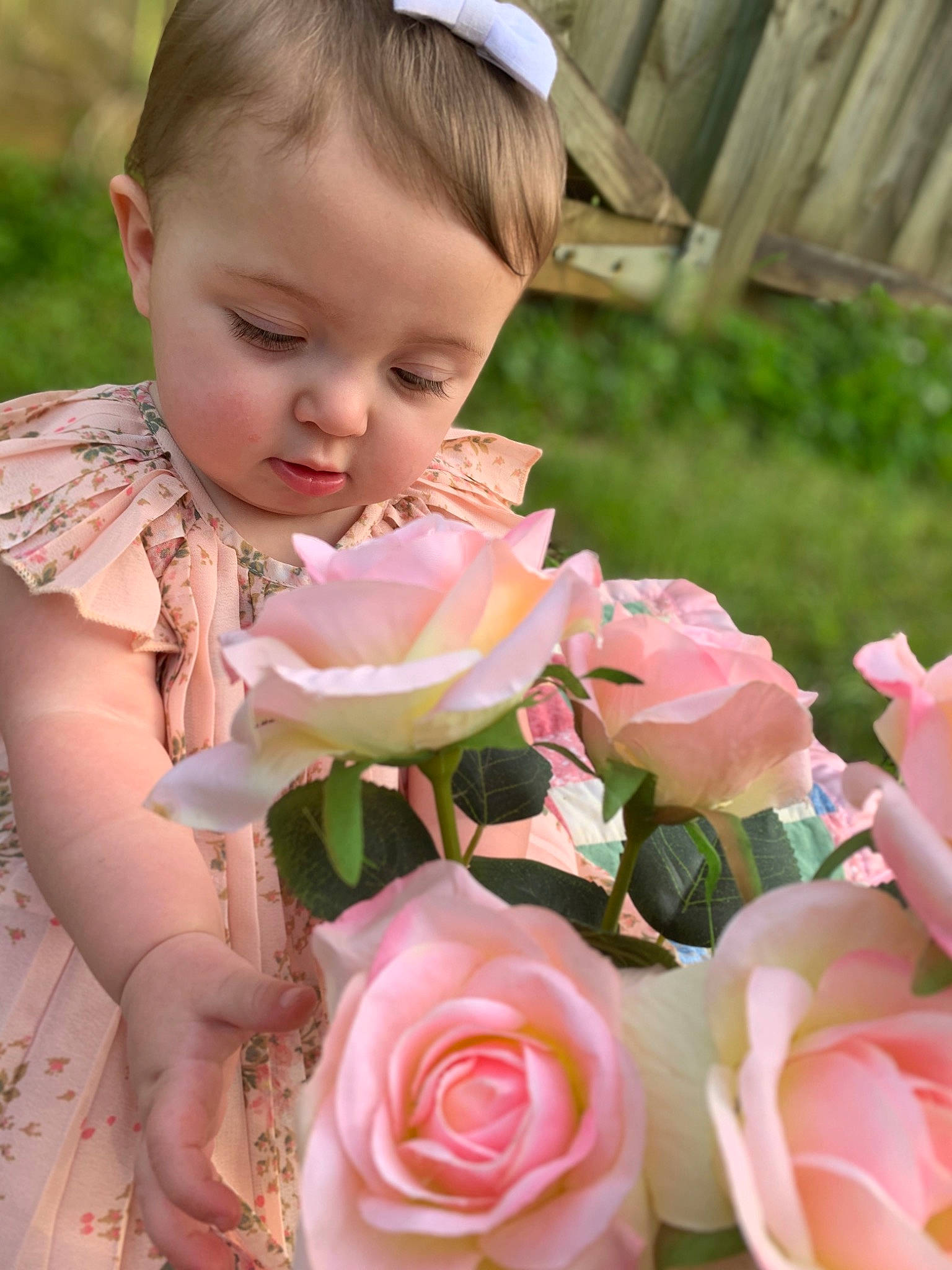 Danielle is registered to the contest to win money with this photo: baby_toddler_clothing, dress, eye, face, flower, hand, happy, head, hybrid_tea_rose, leaf, natural_environment, nature, orange, people_in_nature, person, petal, photograph, pink, plant, skin