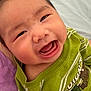 baby, child, smiling, happy, face, mouth_open, green_shirt, striped_clothing, person, infant, joy, cute, portrait, close_up, skin, head, eyes, tongue, sitting, indoor
