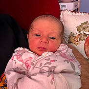 Cali joined the competition — help win amazing prizes! baby, child, cozy, cushion, cute, eyes, face, floral, home, indoor, infant, newborn, onesie, person, pillow, resting, sleepy, soft, warm, wrapped