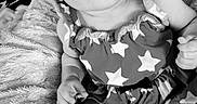 Adalynn is registered to the contest to win money with this photo: baby, infant, child, portrait, smiling, happy, headband, bow, dress, stars, blanket, soft, sitting, indoor, black_and_white, close_up, face, eyes, hand, family_photo