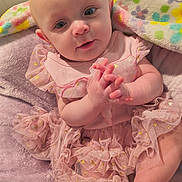 Adalynn joined the competition — help win amazing prizes! baby, bald, bed, blanket, child, closeup, cozy, cute, eyes, face, hands, happy, indoors, infant, pink_dress, plush_blanket, portrait, sitting, smiling, sparkles