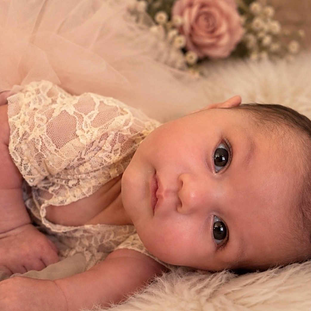 Adelina is registered to the contest to win money with this photo: baby, infant, child, portrait, lying_down, wide_eyes, face, smiling, fluffy_blanket, lace_clothing, pink_tulle, roses, flowers, soft_lighting, indoor, newborn_photography, close_up, cute, cozy, photography