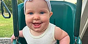 Iris joined the competition — help win amazing prizes! baby, child, swing, playground, outdoor, smiling, headband, blue_eyes, white_clothing, happy, infant, green_swing, summer, park, daylight, cute, young_child, fun, play, person