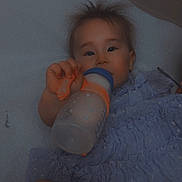 Alina is registered to the contest to win money with this photo: baby, infant, child, bottle, drinking, portrait, indoor, blanket, dress, diaper, sitting, lying_down, face, eyes, hair, hand, smiling, cozy, text_overlay, hello