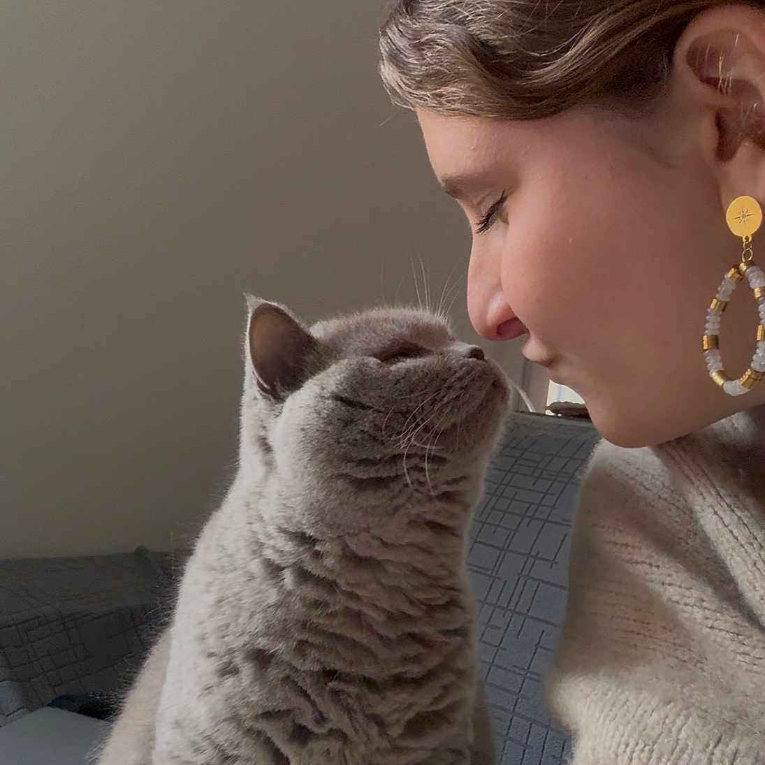 Oïana participe au concours pour gagner de l'argent avec cette photo : affection, cat, closeup, couch, cozy, earring, face, feline, fur, gray_cat, human, indoor, intimate, nose_to_nose, person, pet, portrait, soft_light, sweater, whiskers