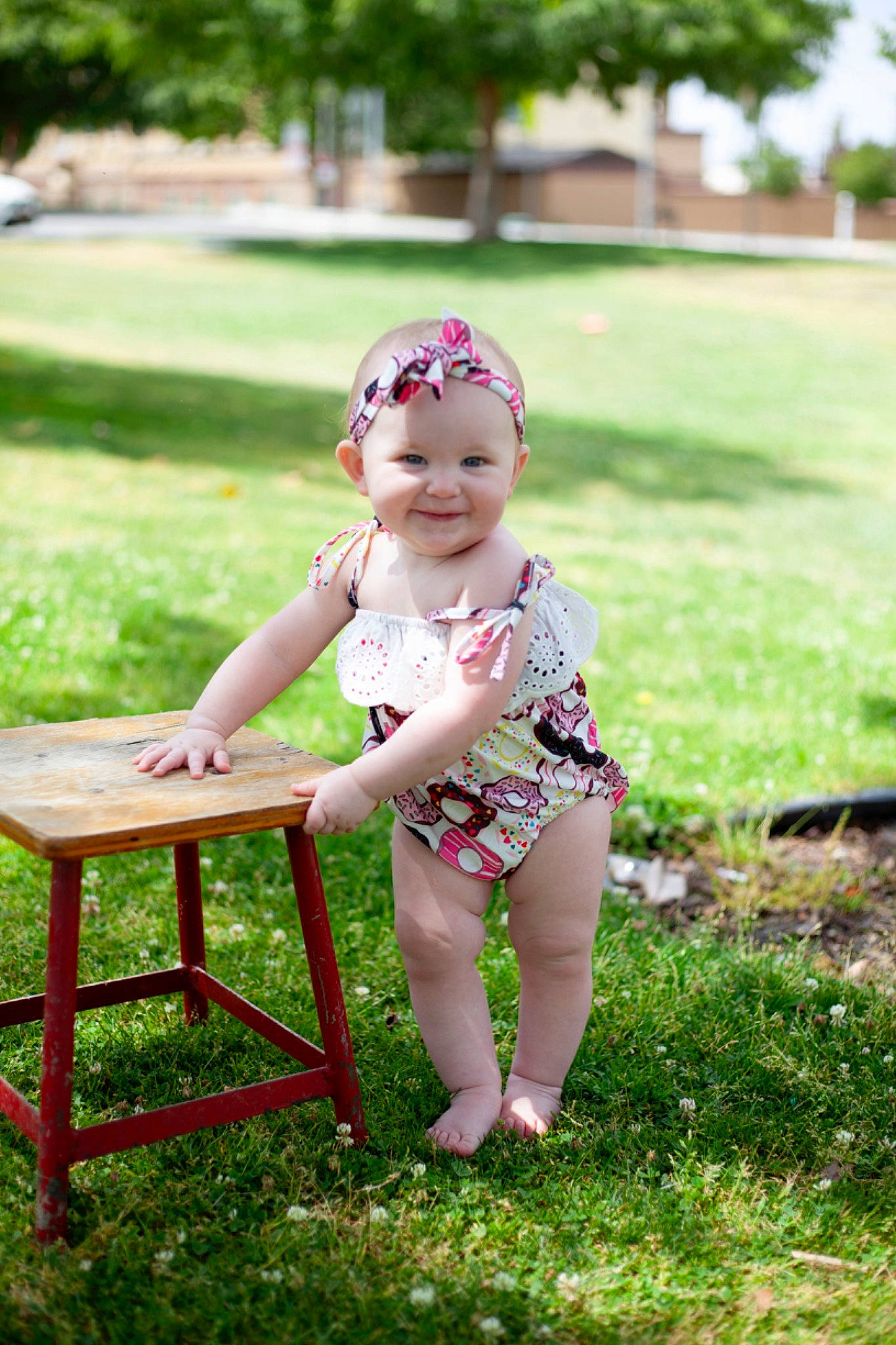 Charlotte is registered to the contest to win money with this photo: baby, baby_toddler_clothing, child, dress, grass, happy, hat, headwear, joy, leaf, leg, leisure, morning, outdoor_furniture, people_in_nature, person, plant, shorts, skin, smile