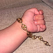 Kassim participe au concours pour gagner de l'argent avec cette photo : child, arm, hand, fist, bracelet, gold_chain, jewelry, skin, baby, infant, close_up, texture, fabric, couch, soft, resting, casual, indoor, accessory, cute