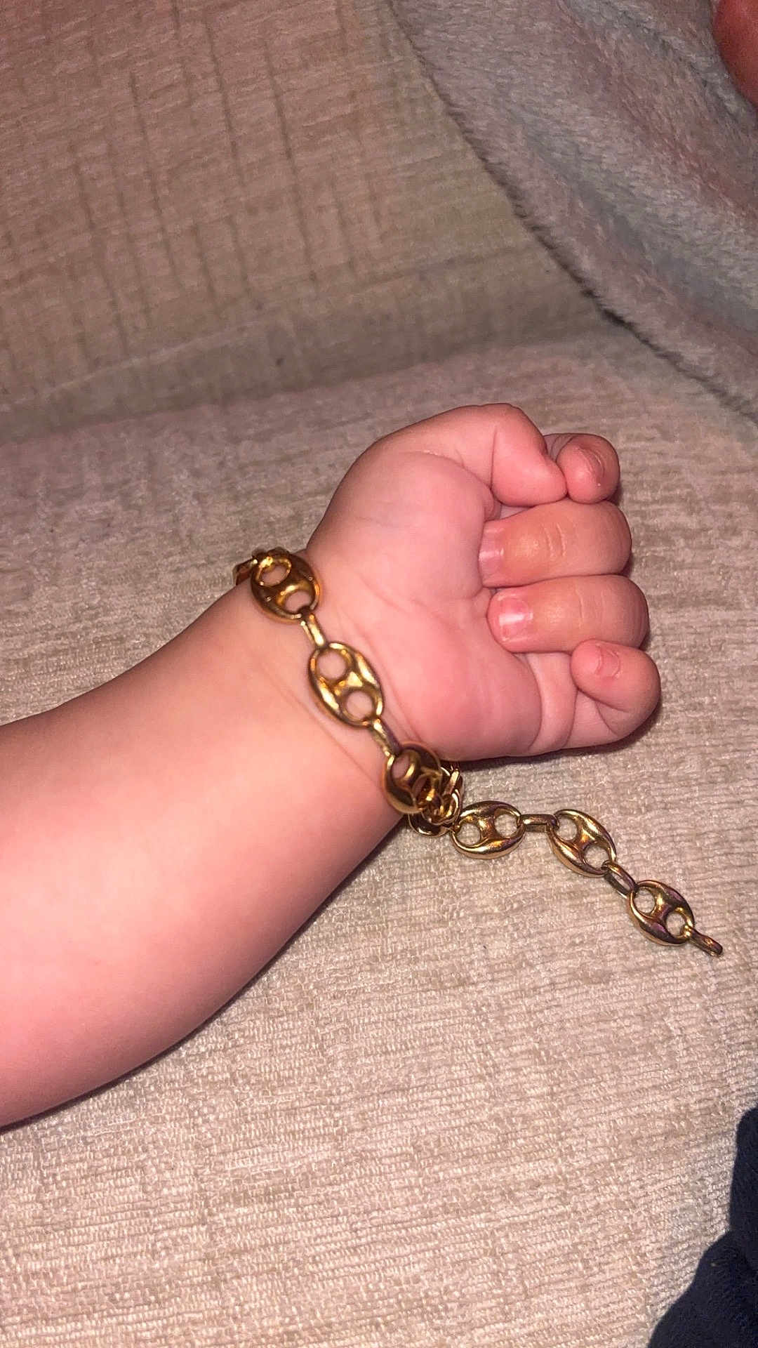 Kassim participe au concours pour gagner de l'argent avec cette photo : child, arm, hand, fist, bracelet, gold_chain, jewelry, skin, baby, infant, close_up, texture, fabric, couch, soft, resting, casual, indoor, accessory, cute