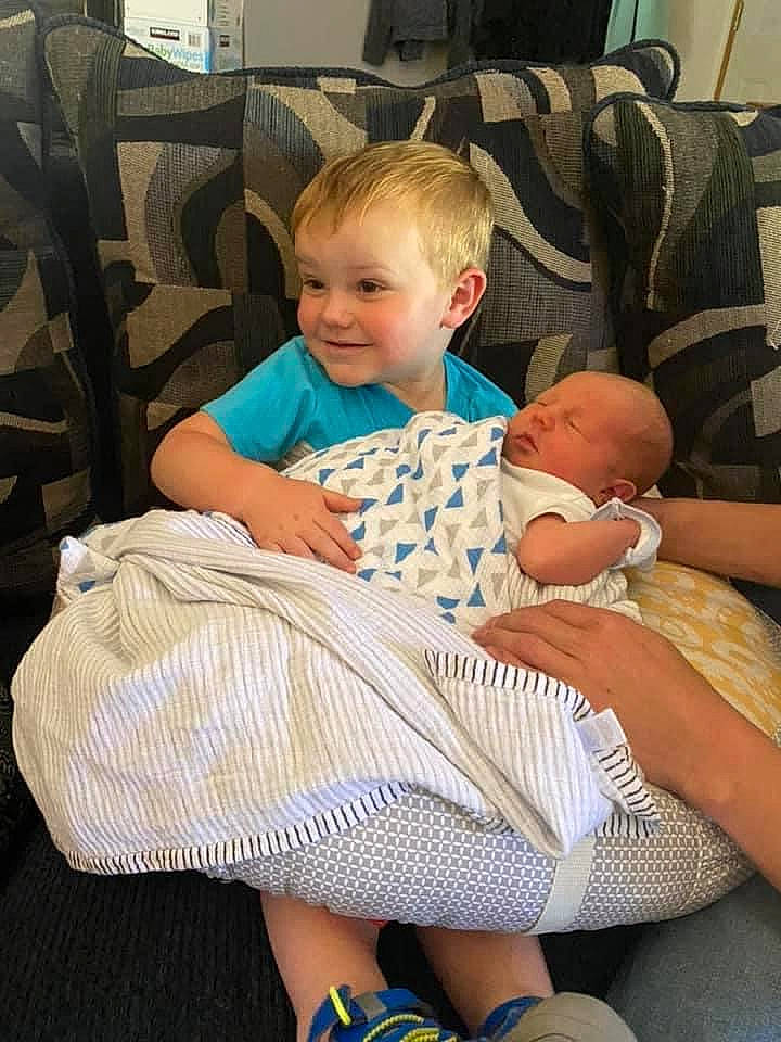 Westyn joined the competition — help win amazing prizes! baby, baby_toddler_clothing, chair, child, comfort, couch, fun, human_leg, joy, lamp, lap, leg, person, picture_frame, sitting, skin, smile, sock, television, thigh