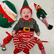 ézïo participe au concours pour gagner de l'argent avec cette photo : baby, smiling, elf_costume, red_and_white_stripes, green_clothing, holiday, christmas, plush_toys, elf_dolls, pillow, happy, infant, lying_down, cute, festive, indoor, child, toy, face, red_hat