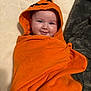 Macey is registered to the contest to win money with this photo: baby, child, orange_towel, hood, smile, face, blanket, cute, infant, wrapped, happy, indoors, soft, cozy, portrait, towel, skin, head, eyes, young