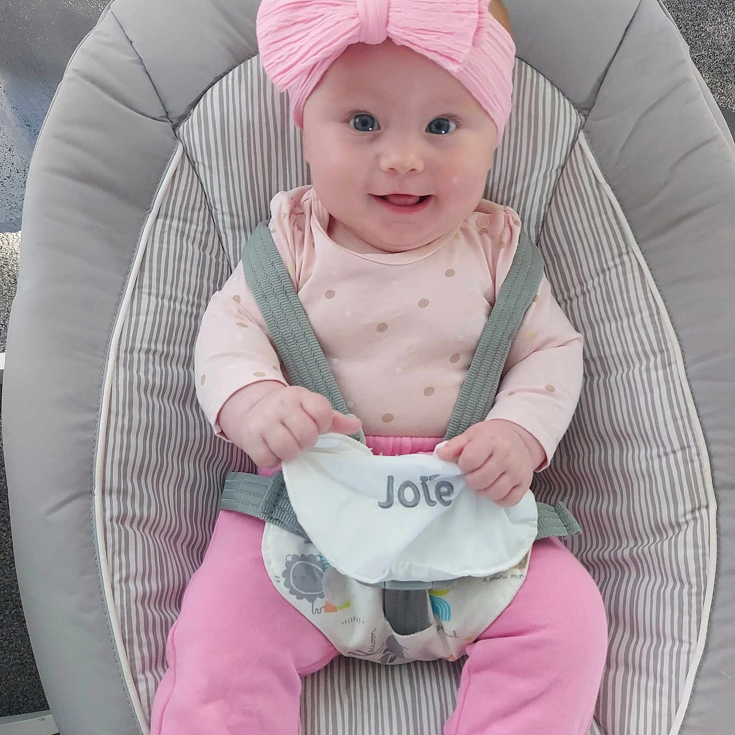 Ella-Rosa is registered to the contest to win money with this photo: baby, baby_clothing, baby_rocker, carpet, child, cute, happy, headband, holding, indoor, infant, person, pink_bow, pink_pants, polka_dot_shirt, portrait, safety_harness, seated, smiling, striped_fabric