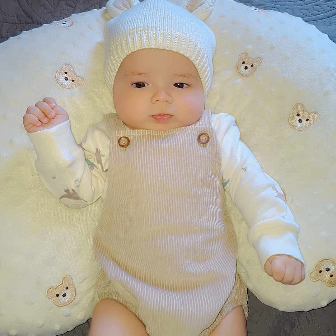 Jaziel is registered to the contest to win money with this photo: baby, bear_ears, bear_embroidery, bed, blanket, child, chubby_cheeks, corduroy, cushion, cute, hat, indoor, infant, knit_hat, person, portrait, romper, sleepwear, soft_toys, white_clothing