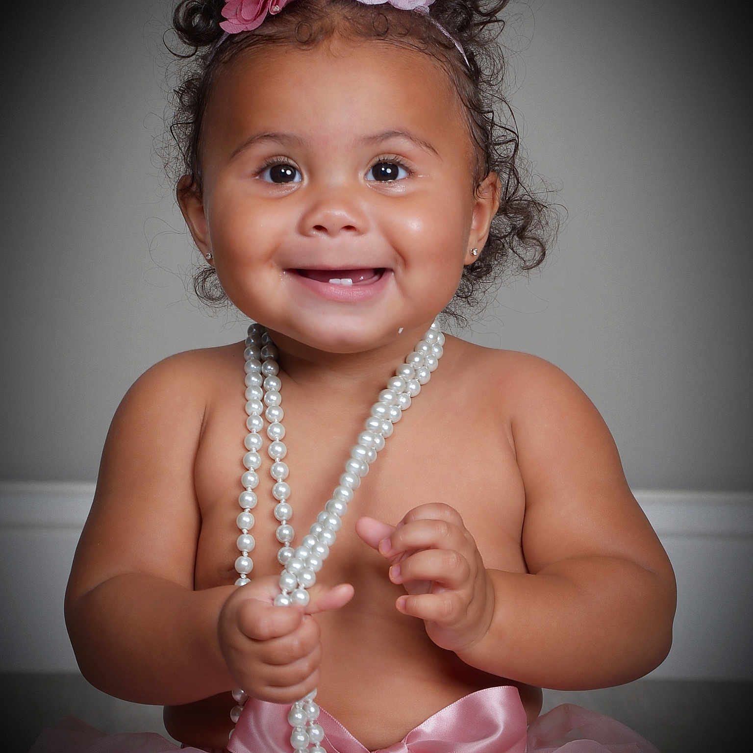 Gianna joined the competition — help win amazing prizes! baby, child, smile, pearls, pink, tutu, headband, curly_hair, portrait, happy, cute, toddler, jewelry, ribbon, sitting, studio, person, accessory, closeup, innocence