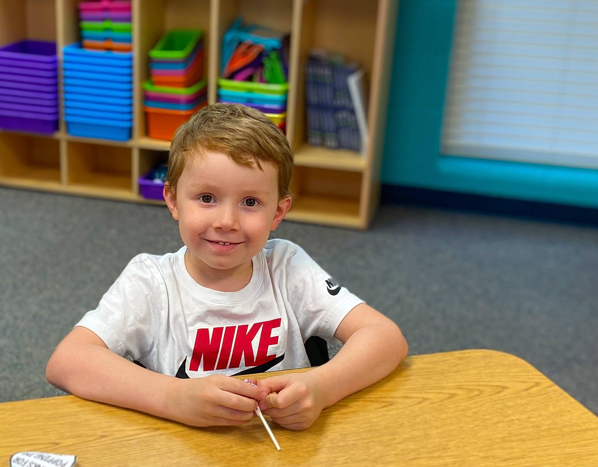 Stephen is registered to the contest to win money with this photo: child, event, finger, flooring, fun, hand, happy, hardwood, joy, leisure, person, play, recreation, room, sitting, smile, t_shirt, table, toddler, varnish