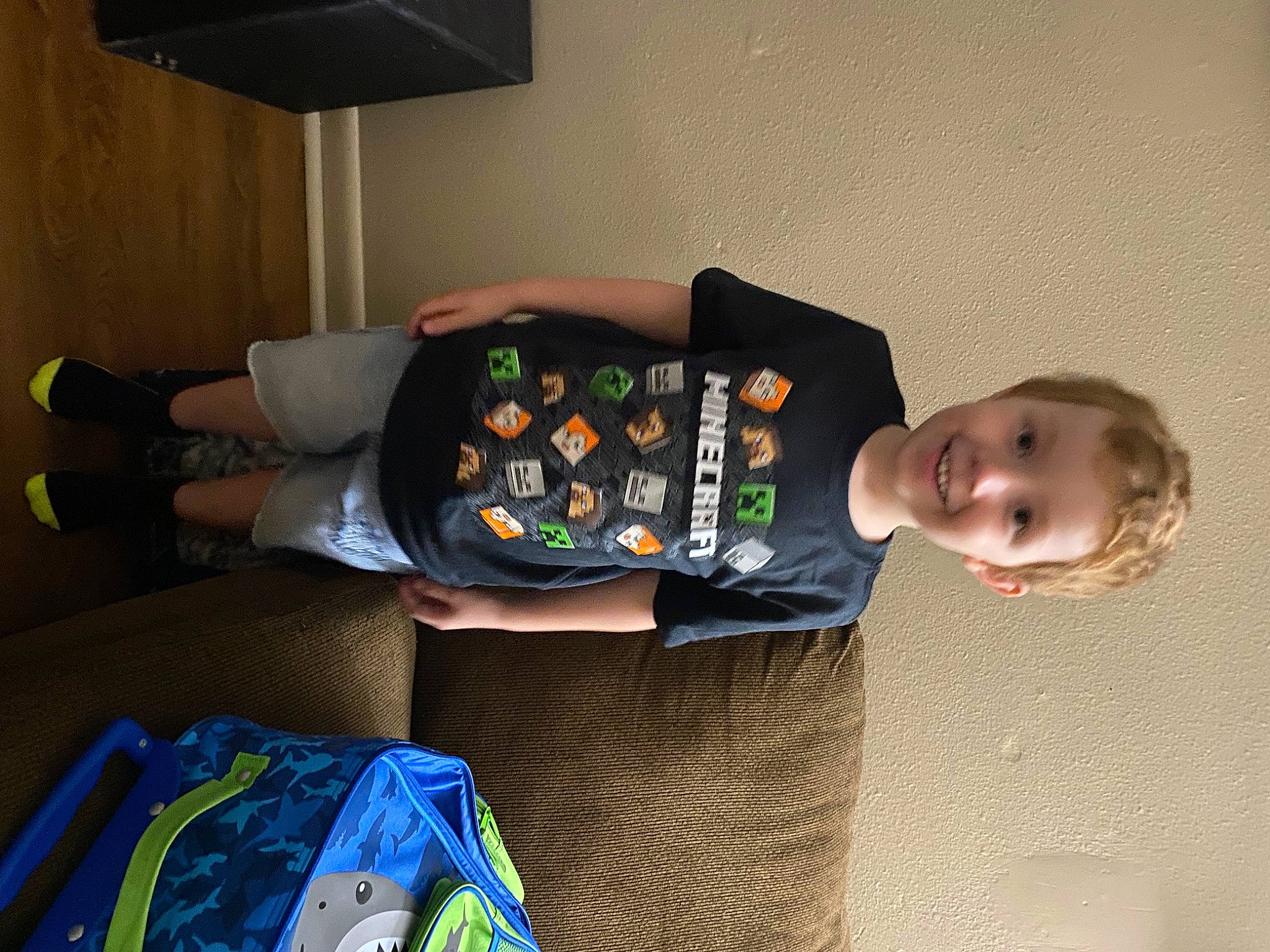Stephen is registered to the contest to win money with this photo: baby, baby_products, baby_toddler_clothing, bag, child, comfort, flooring, fun, joy, knee, lamp, lap, luggage_and_bags, person, room, sitting, sleeve, smile, sock, sweatpant