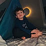 Oconor a rejoint le concours — aidez-le/la à gagner de superbes lots ! child, bed, blanket, tent, blue_fabric, light, circular_light, indoor, nighttime, cozy, relaxed, person, foot, hand, wall, room, casual_clothing, head, face, portrait