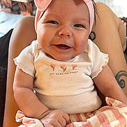 Layla joined the competition — help win amazing prizes! baby, smiling, headband, pink_bow, white_shirt, striped_shorts, infant, person, indoor, happy, cute, child, clothing, sitting, portrait, skin, hand, legs, tattoo, closeup