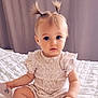 baby, child, infant, portrait, cute, pigtails, blonde_hair, blue_eyes, sitting, bed, quilt, clothing, indoor, soft_lighting, curious, young_child, person, cute_outfit, expression, hands