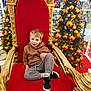 Hugo a rejoint le concours — aidez-le/la à gagner de superbes lots ! boy, casual_clothing, celebration, child, christmas_lights, christmas_tree, decoration, festive, golden_frame, happy, holiday, hoodie, indoor, ornaments, portrait, red_cushion, seasonal, smiling, sneakers, throne
