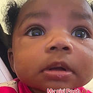 Janiyah is registered to the contest to win money with this photo: baby, child, close_up, curly_hair, cute, expression, face, head, indoor, infant, looking_up, person, pink_clothing, portrait, skin, social_media, tear, text_overlay, wide_eyes, young_child