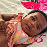 Janiyah is registered to the contest to win money with this photo: baby, blanket, child, close_up, clothing, colorful, comfort, curly_hair, eyes, face, floral_pattern, hand, infant, number, peach, person, pink, skin, soft_texture, tenderness