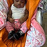 Janiyah joined the competition — help win amazing prizes! baby, black_shoes, blanket, cartoon_pants, child, comfort, cozy, cute, floral_pattern, headband, indoors, infant, newborn, orange_blanket, person, pink_clothing, resting, sleeping, soft_fabric, white_tank_top