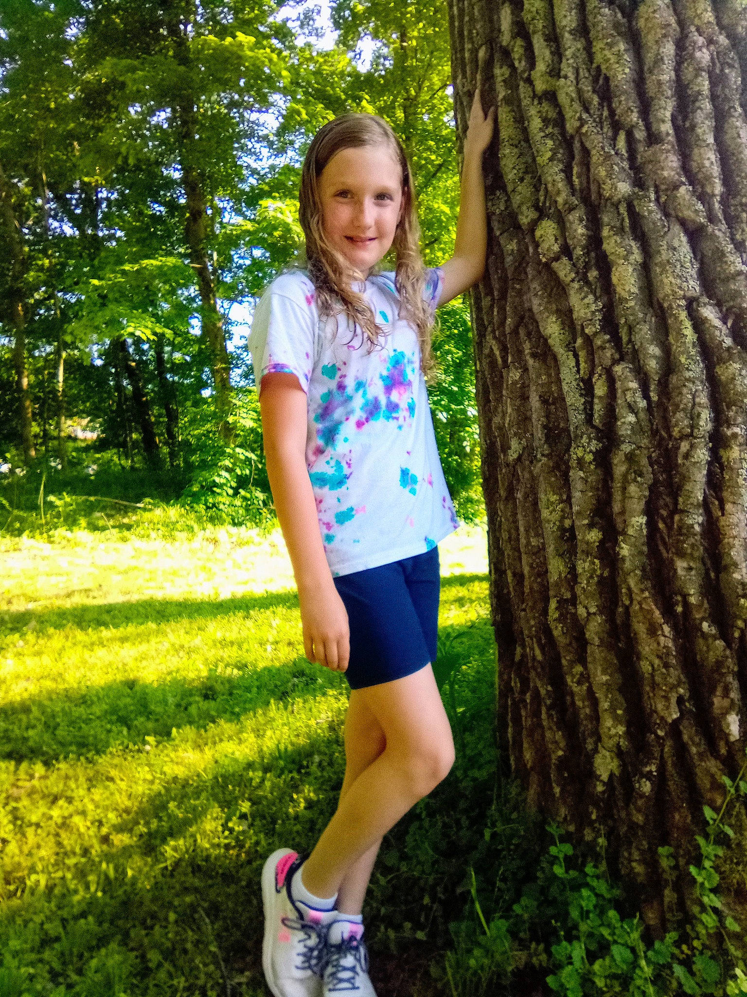Makenzie is registered to the contest to win money with this photo: eye, footwear, grass, green, hair, happy, joy, leaf, leg, leisure, nature, people_in_nature, person, plant, shorts, smile, standing, summer, t_shirt, tree