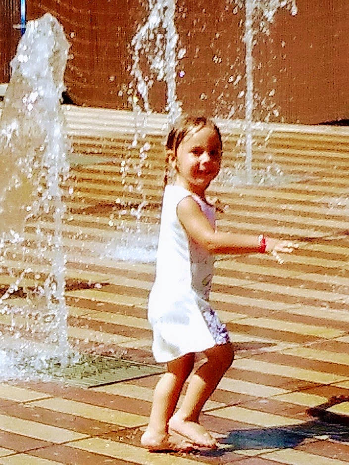 Emy a rejoint le concours — aidez-le/la à gagner de superbes lots ! beauty, child, dress, event, facial_expression, flash_photography, foot, fountain, fun, gesture, happy, human_leg, leisure, people_in_nature, person, sandal, standing, toddler, waist, water