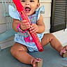Emersyn is registered to the contest to win money with this photo: baby, child, smiling, blue_chair, pink_bow, red_bubble_wand, sandals, outdoor, happy, cute, watch, dress, sitting, face, person, wooden_chair, playful, toy, summer, fun
