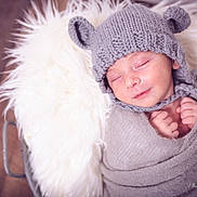 Tiago a rejoint le concours — aidez-le/la à gagner de superbes lots ! newborn, baby, sleeping, knitted_hat, bear_ears, swaddled, blanket, soft_texture, cozy, infant, cute, portrait, indoors, wooden_floor, wrapped, peaceful, small_hands, closeup, headwear, resting