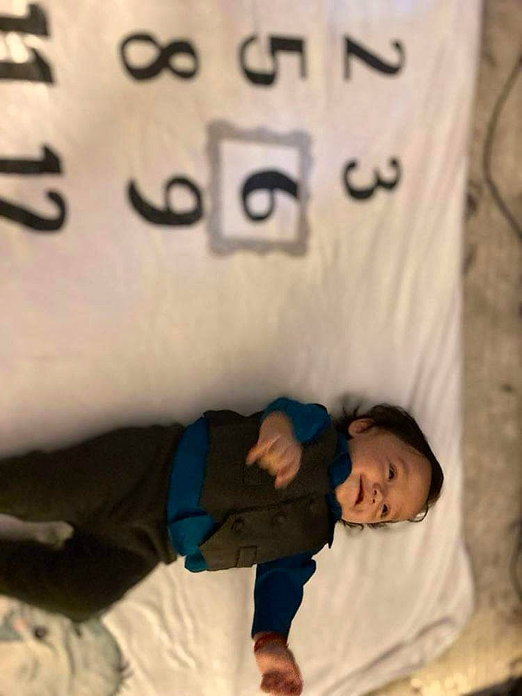 Marcelo is registered to the contest to win money with this photo: bedding, child, comfort, elbow, finger, font, fur, gesture, handwriting, happy, linens, nap, person, room, sleeve, t_shirt, textile, thumb, toddler, white