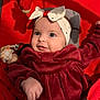 Violette participe au concours pour gagner de l'argent avec cette photo : baby, infant, headband, bow, red_clothing, velvet, cushion, seat, toy, soft_toy, smile, blue_eyes, hand, cute, indoor, child, person, portrait, happy, cozy