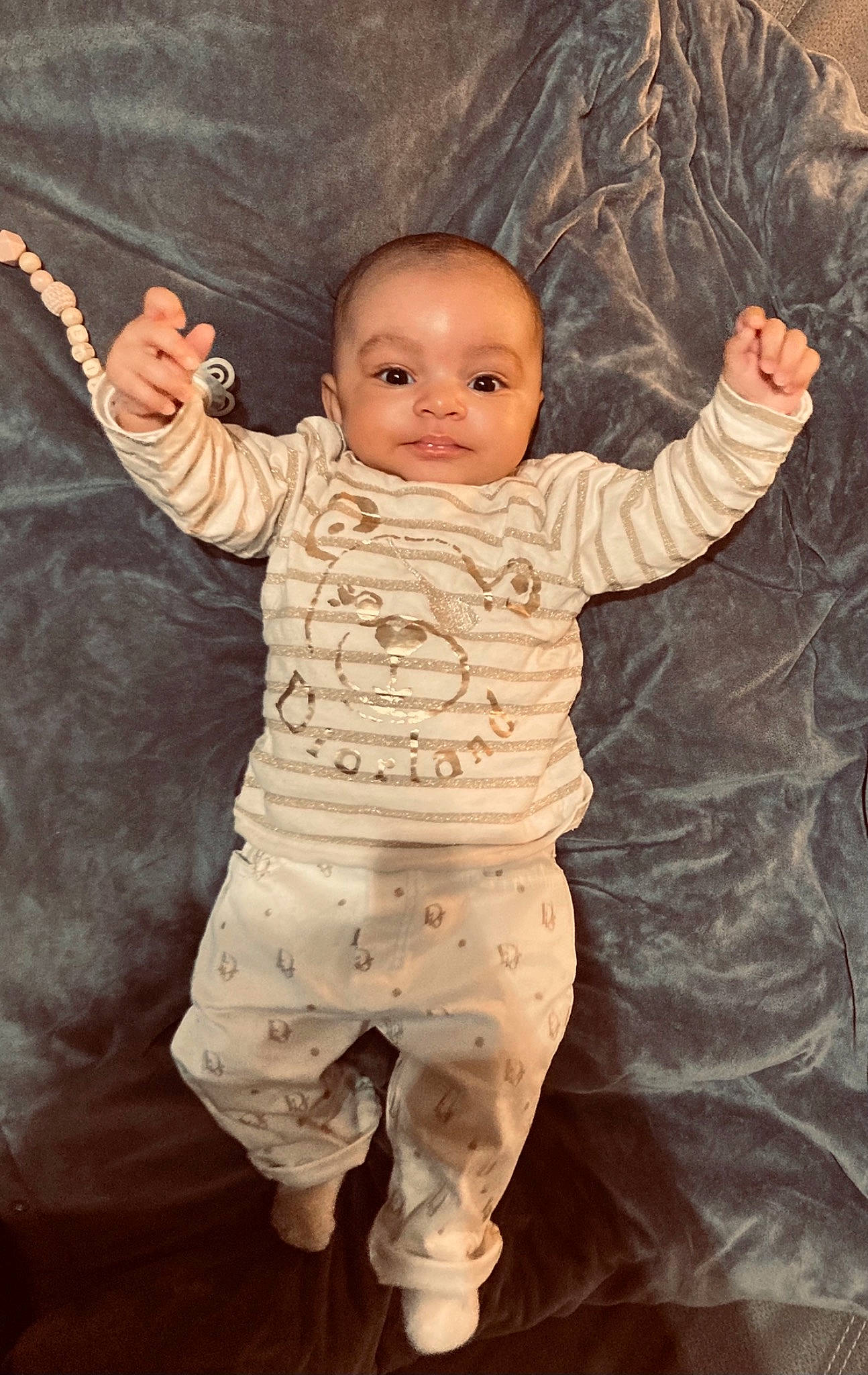 Elia participe au concours pour gagner de l'argent avec cette photo : arm, baby, baby_toddler_clothing, cheek, clothing, eye, face, finger, gesture, hand, happy, head, human_body, iris, nose, outerwear, person, skin, sleeve, thumb