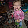 Camilla is registered to the contest to win money with this photo: toddler, child, indoor, pink_shirt, green_slippers, snack, rug, wooden_table, toy, kids_furniture, carpet, floor, smiling, person, home, living_room, playroom, furniture, cute, happy