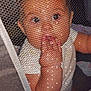 Natalie is registered to the contest to win money with this photo: baby, baby_garment, child, closeup, curious, cute, eyes, fabric, face, fingers, hand, indoor, infant, mesh, netting, person, portrait, skin, sucking, white_clothing