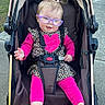 Oakleigh is registered to the contest to win money with this photo: baby, child, stroller, glasses, pink_clothing, leopard_print, heart_design, outdoor, sidewalk, happy, smiling, pigtails, hair_ties, footwear_barefoot, seatbelt, sunlight, portrait, infant, cute, person