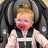 Oakleigh joined the competition — help win amazing prizes! baby, child, car_seat, pacifier, glasses, pink_outfit, giraffe_pattern, seatbelt, safety, infant, toddler, hair, face, portrait, outdoor, child_safety, cute, expression, baby_clothes, young_child