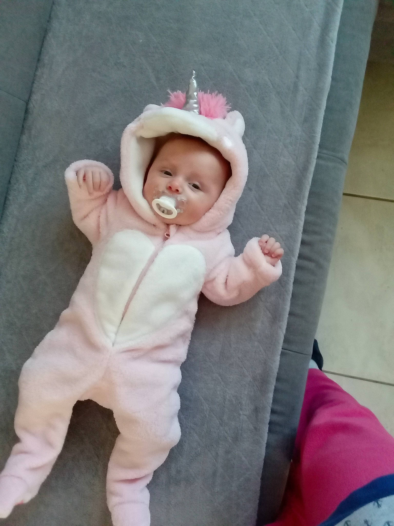 Nelly participe au concours pour gagner de l'argent avec cette photo : baby, baby_products, baby_toddler_clothing, child, comfort, costume_hat, couch, fashion_accessory, foot, fur, linens, magenta, pattern, person, pink, product, sitting, sleeve, sock, textile