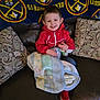 Romeo is registered to the contest to win money with this photo: child, smiling, red_jacket, blanket, juice_bottle, couch, leather, pillow, patterned_pillow, indoor, denver_nuggets_blanket, happy, young_child, casual_clothing, home_interior, seated, footwear, cozy, relaxed, portrait