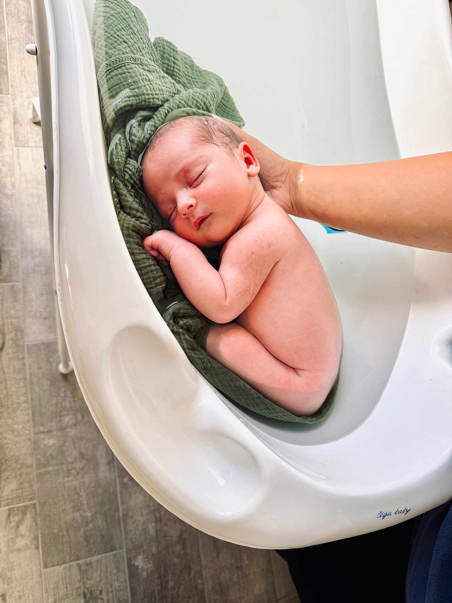 Lowenn a rejoint le concours — aidez-le/la à gagner de superbes lots ! newborn, baby, sleeping, bathtub, hand, towel, skin, peaceful, infant, cute, resting, young_child, indoors, human, child, supporting_hand, floor, white, green, relaxing